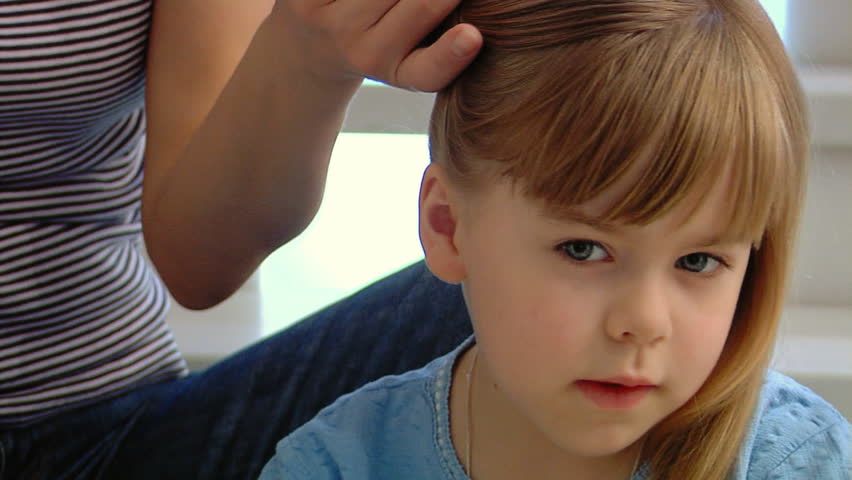 Mum braids tresses to the little girl. Sequence of shots.