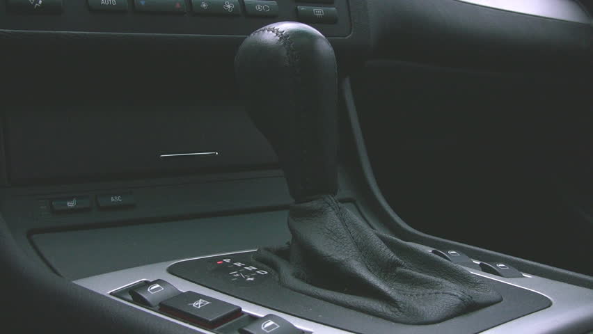 An automobile interior automatic transmission lever, being changed from Park to Drive.