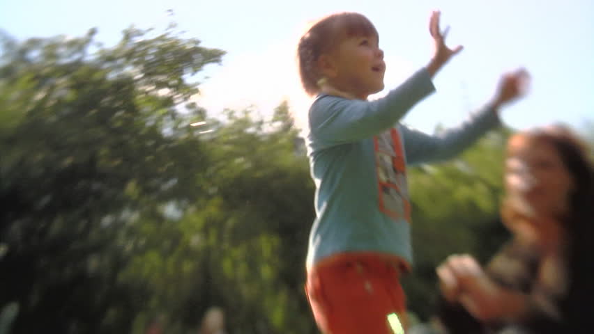 Sequence of soft focus shots. Happy Mum with the little girl playing in the park