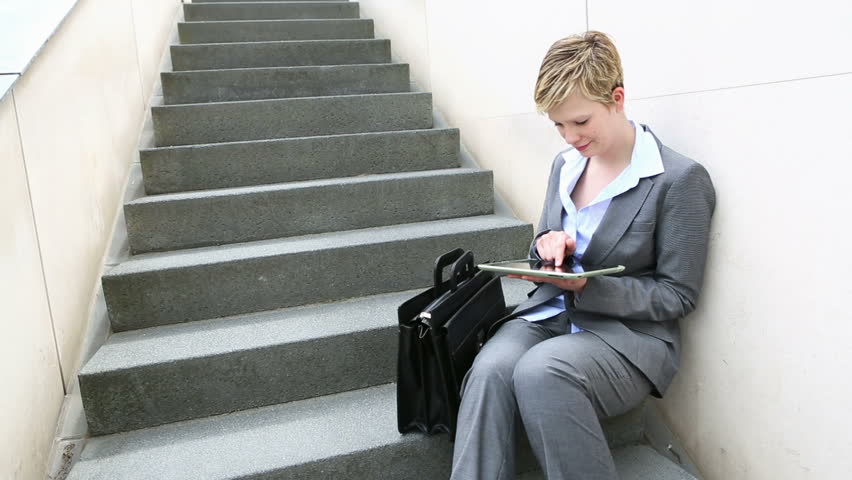 Young businesswoman working with tablet PC on urban stairs
