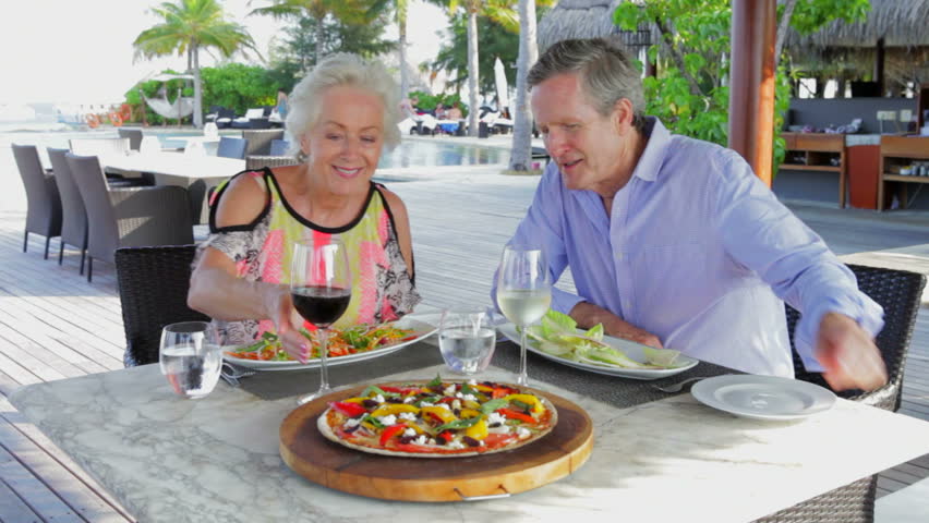 Senior Couple Enjoying Meal In Outdoor Restaurant
