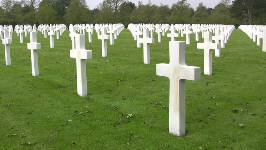 Pan of white crosses and graves at The Normandy American Cemetery and Memorial at Omaha Beach, Normandy, France.