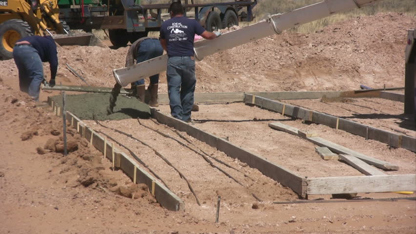 Three men working with cement for a new home foundation.