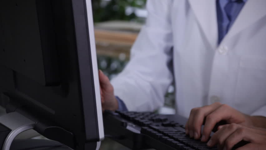 Two doctors, technicians, or scientists doing research together on a computer.