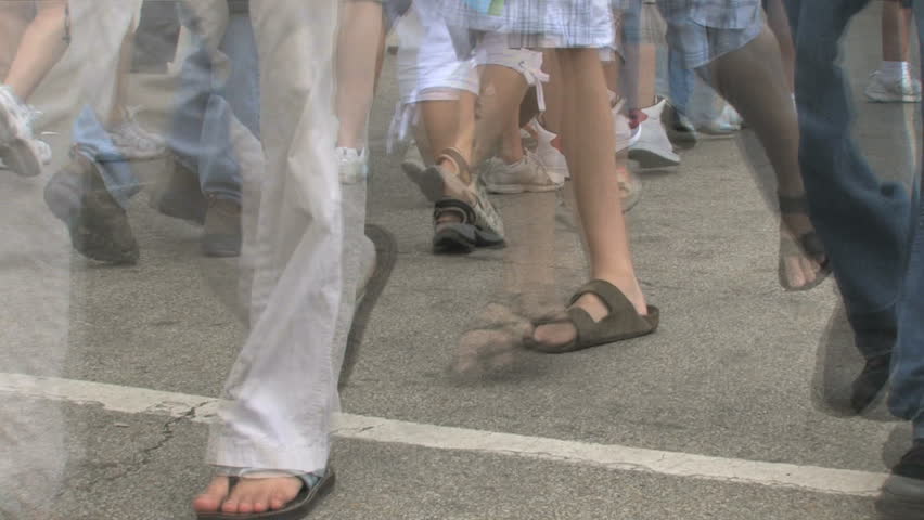 Crowd of feet walking on the pavement