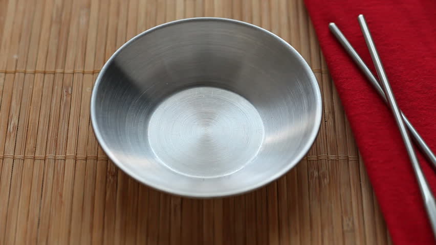 Soy sauce being poured into a silver dish.