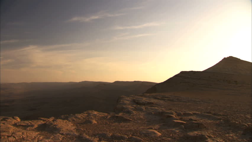 Pan of a large crater in Negev Desert at sunset magic hour