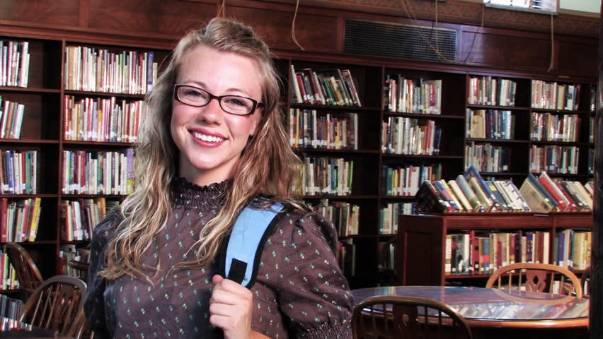 A confident student proudly looks at the camera and smiles.