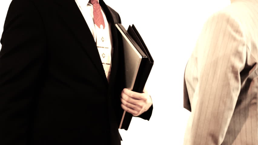 A businessman and a businesswoman shaking hands to seal the deal. High contrast tint for drama