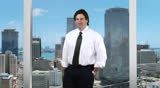 Young businessman standing in center - skyline background