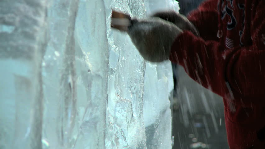 Ice Carving 3- Ice carver using a hand chisel for an outdoor display.