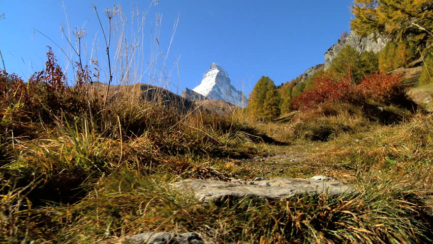 Fall in an alpine meadow, Zermatt, with hikers & the Matterhorn, motion jib
