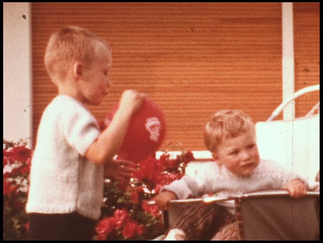 Boy teasing baby brother with balloon (vintage 8 mm amateur film)