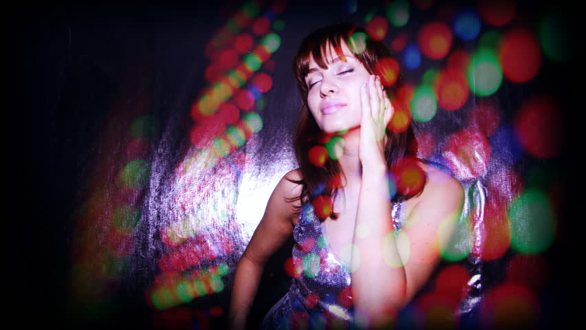 beautiful young woman dances and moves to the groove in a nightclub
