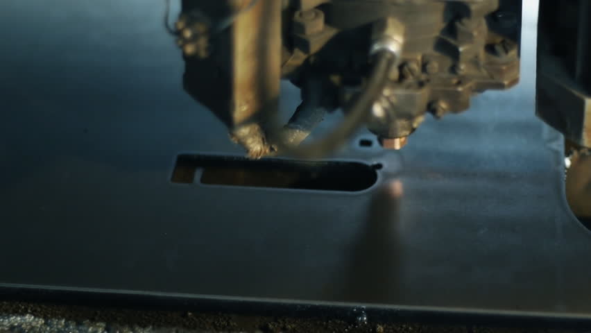 The industrial laser cuts a metal sheet.