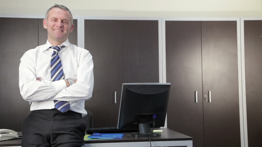 Multiple shots of mid adult businessman looking at camera in office (sequence)