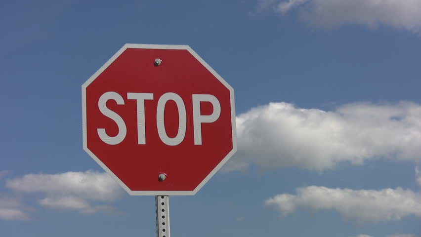 Stop sign with fluffy timelapse clouds. Mellow timelapse.
