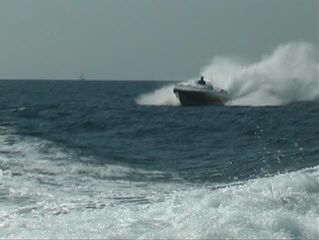 Speedboat jumping over the backwash from a motor yacht