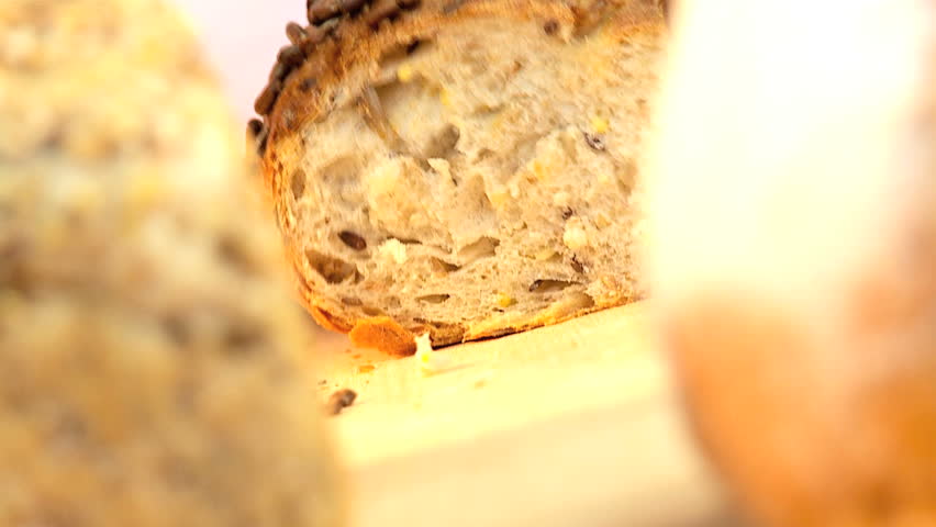 Fresh organic breads baked with healthy nuts & seeds being sliced and served to eat