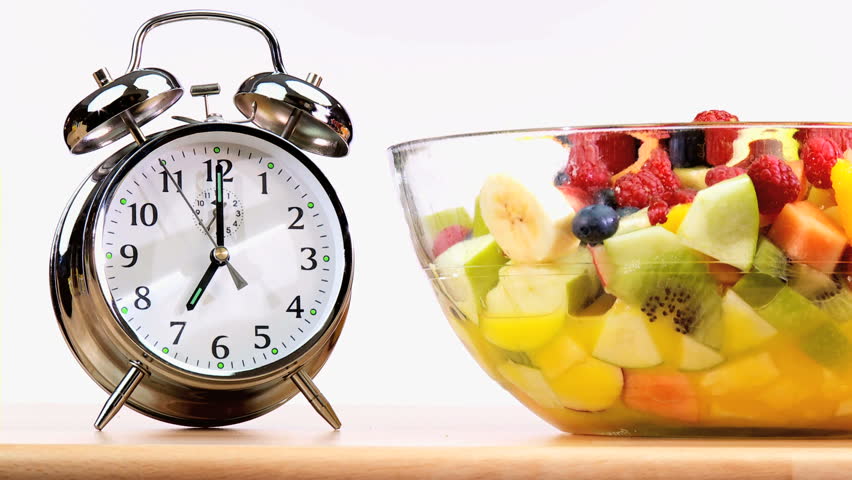 Clock hands indicating that it is time to start eating fresh fruit as part of a balanced healthy diet