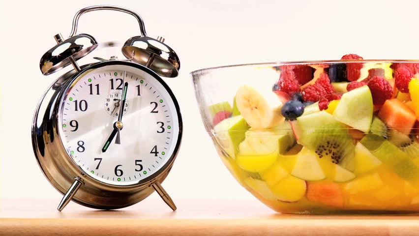 Clock hands indicating that it is time to start eating fresh fruit as part of a balanced healthy diet