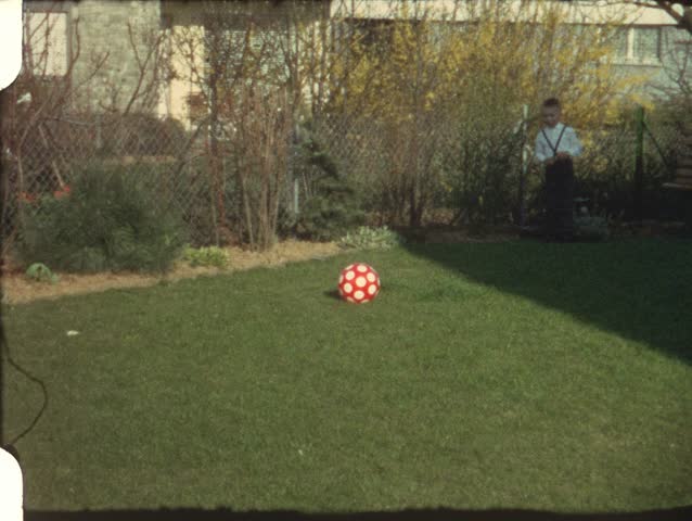 Boy kicking ball in garden (vintage 8 mm amateur film)