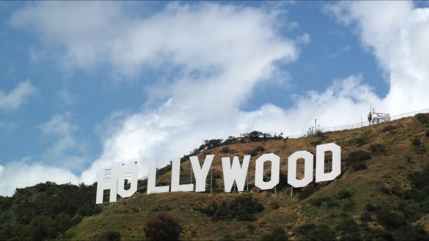 LOS ANGELES - APRIL 12: Famous Hollywood Sign letters on top of hill with clouds moving over blue sky in the background. HD Time lapse. April 12, 2010 in Los Angeles, California.