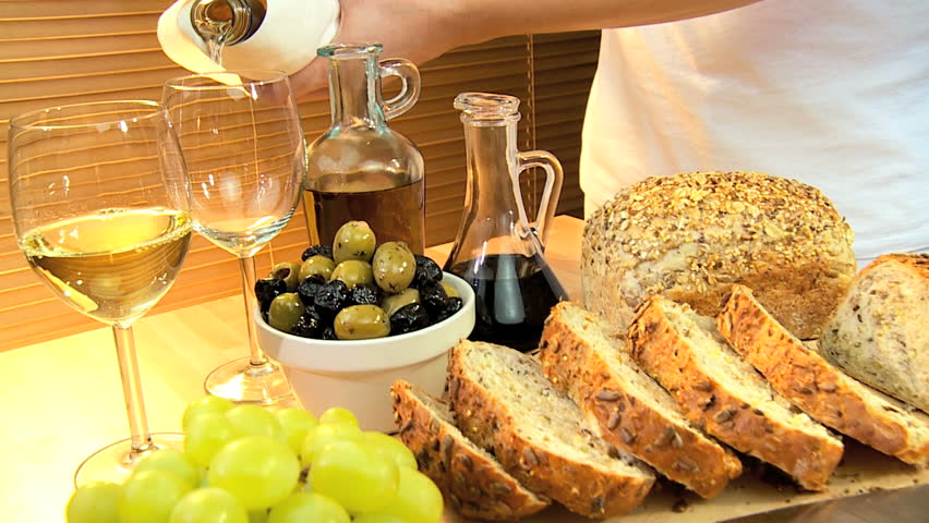 Selection of cheeses, whole-grain bread, oils & fruit with white wine for a healthy modern lifestyle lunch