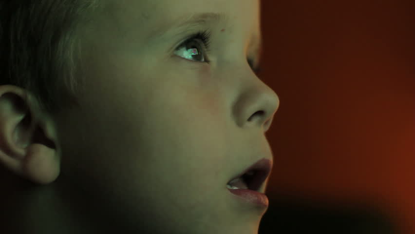 A young boy watching television, closeup