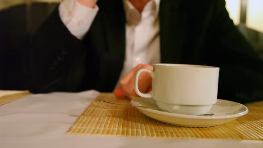 close up of hand of person taking from dining table glass with drink 