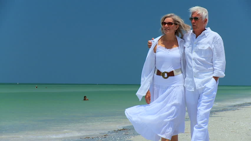 Attractive senior couple enjoying each others company walking on the beach 60FPS