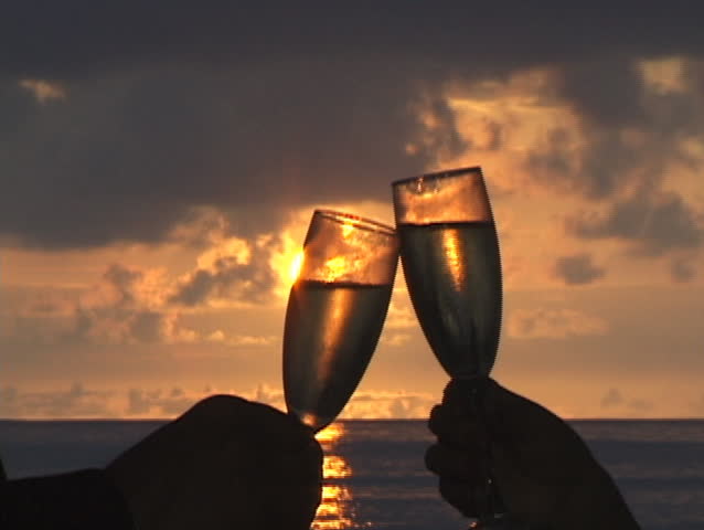 Champagne toast with sunset background.