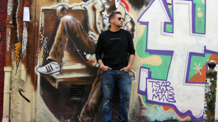 man walks and leans against wall