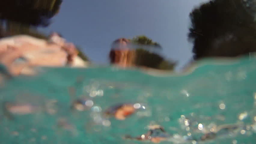 Girl splashing her feet in swimming pool