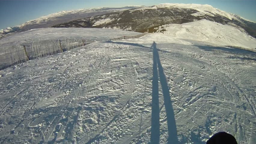 Silhouette of man skiing down slope
