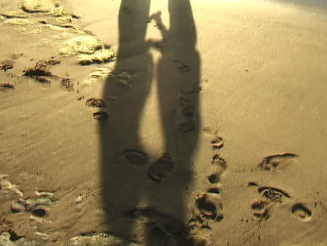 Tilt up from couple shadows to silhouette of kissing