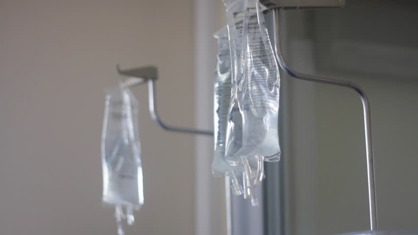 Camera pans down to show two working dialysis machines. Anonymous patient in background.