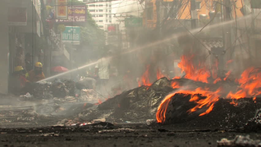 BANGKOK, THAILAND - April 19, 2010: Protesters set barricades built of tires on fire to create smoke screens seeking protection from government snipers