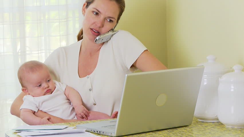 Mother working on laptop with baby