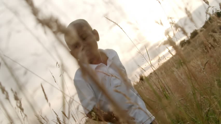 A father and son play in a wheat field on a sunny day.