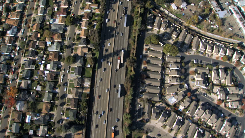 Aerial view of traffic on a freeway with suburban housing either side