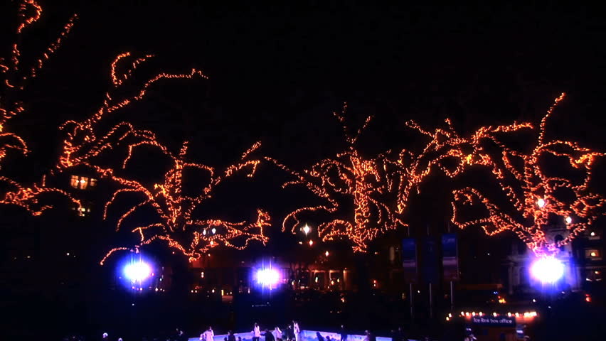 Winter outdoor ice skating with Christmas lights & crowds of people at night