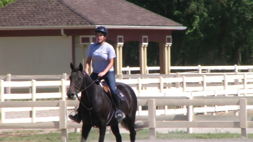 Girl Riding Horse - demonstrating trotting during equestrian lesson.


