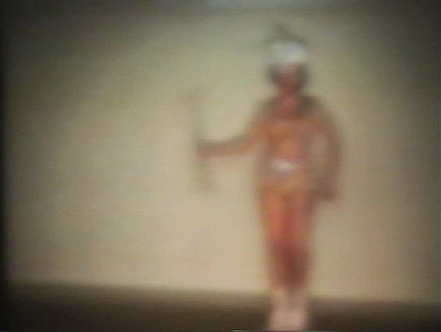 A beautiful teenage girl does her dance routine complete with baton and marching boots.