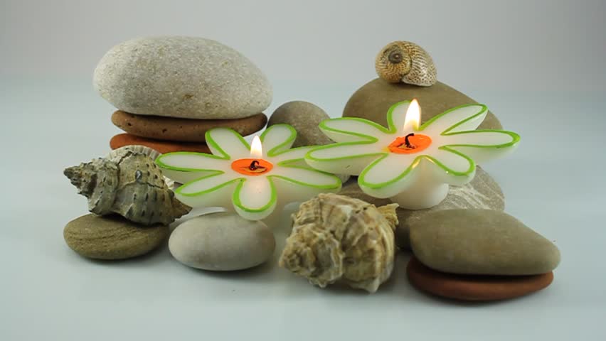Burning candles, seashells and pebbles 