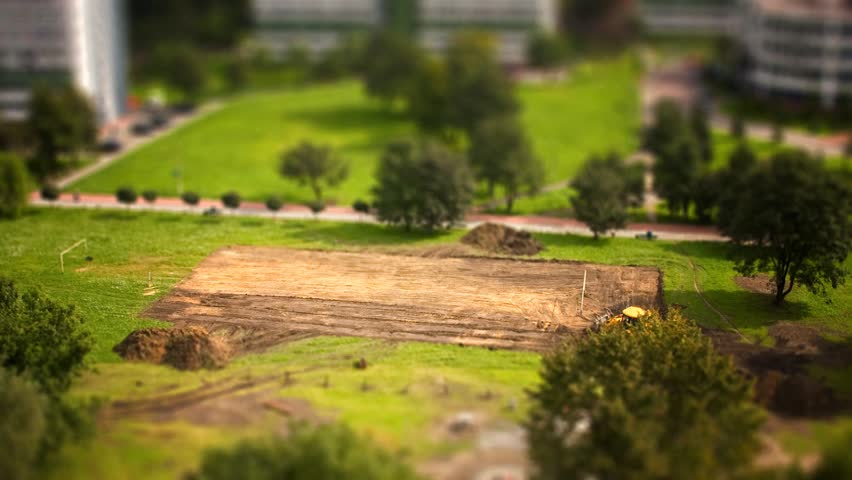 Time lapse and tilt-shift movie from excavator creating background for a football pitch