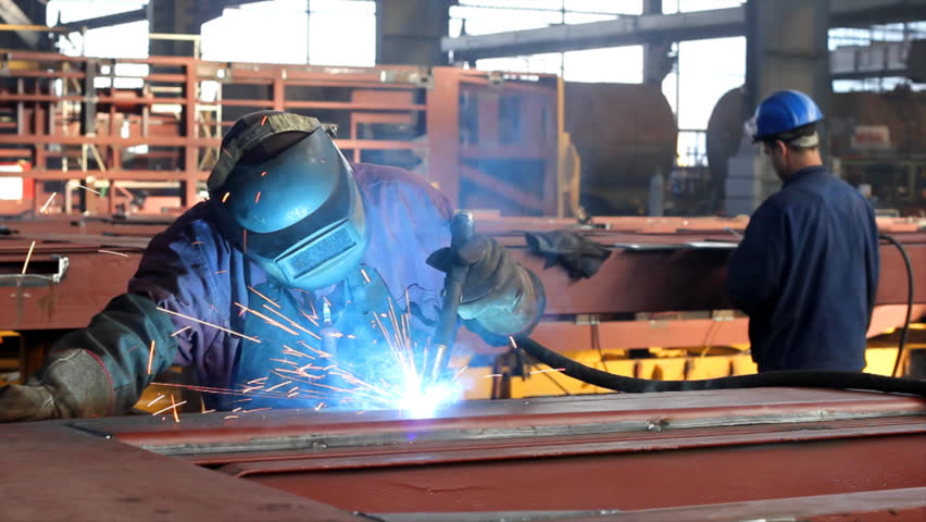 Welder at work in factory
