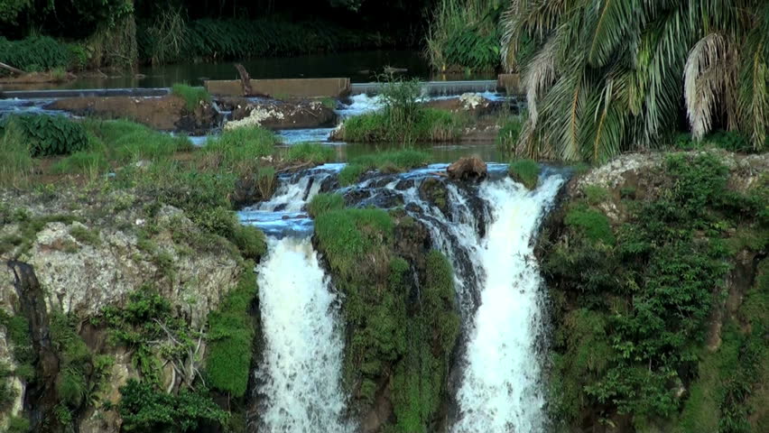 High scenic waterfalls from a rocky stream in a wild tropical nature; zoom out
