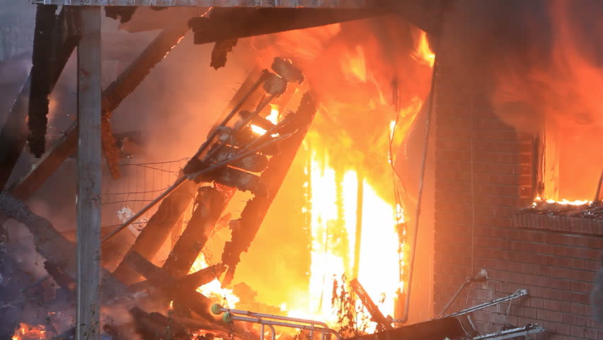 House destroyed by intense fire. Flames engulfing the interior of a home