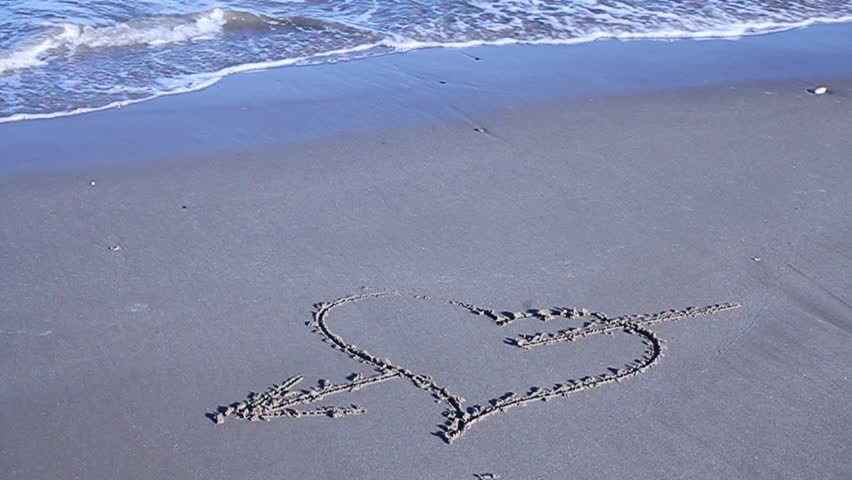 Painted heart in the sand, sea